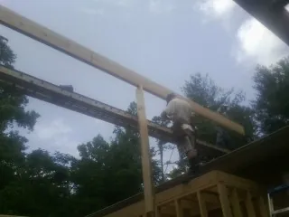 Carpenter setting a ridge beam over a new addition frame — Ice Dam Removal by Roofing Brothers in Tabiona
