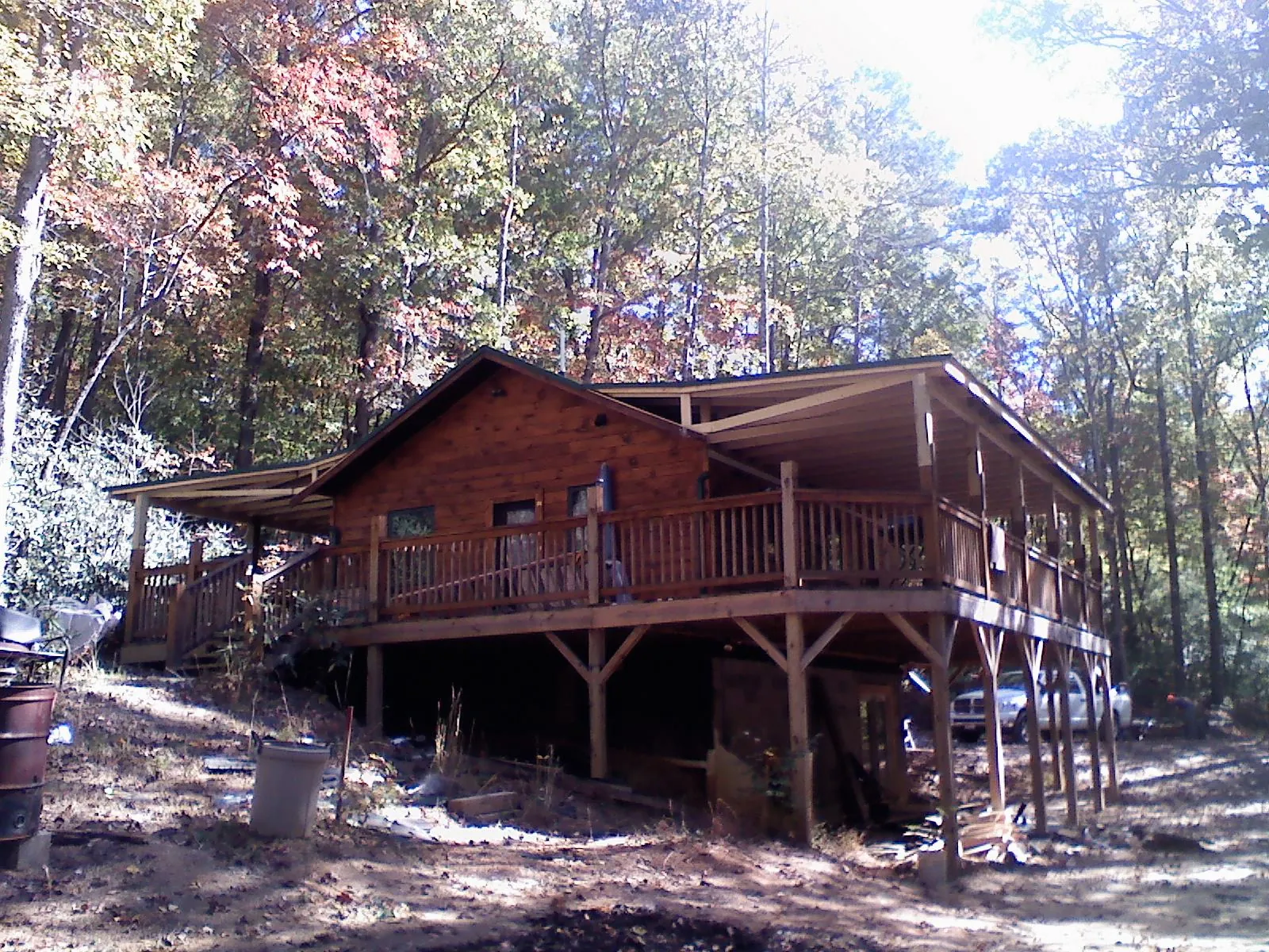 Log cabin with a wraparound porch and metal roof in the fall in Tabiona