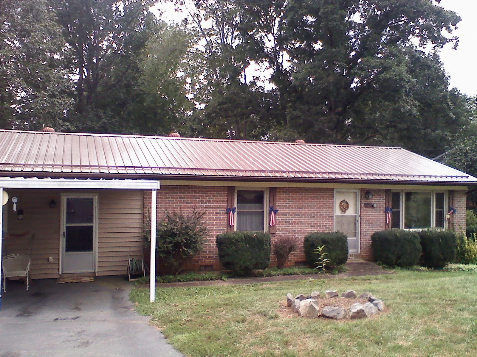 Bronze metal roof and carport on a brick ranch home — Roof Repair work by our crew in Tabiona